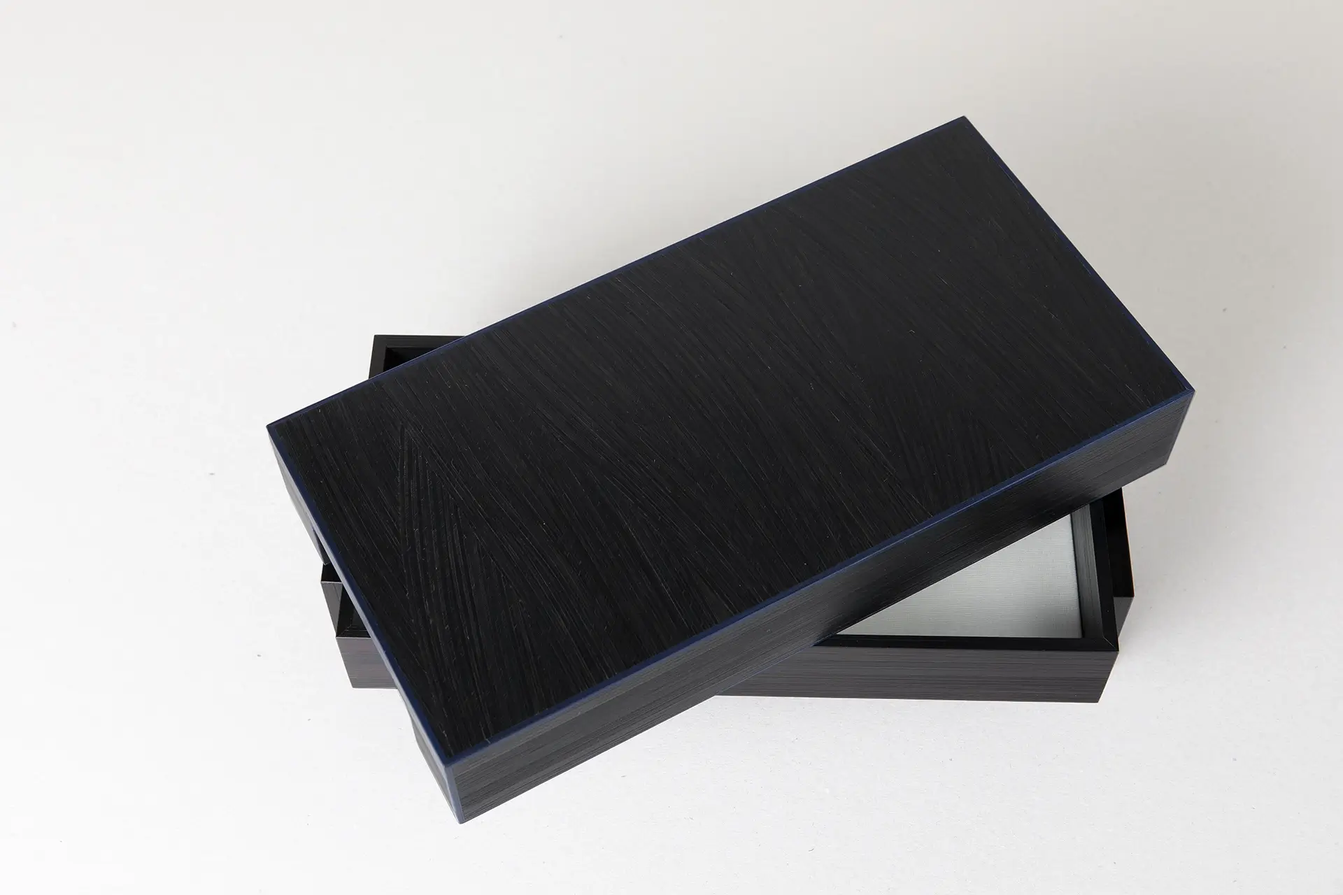 Boite inspirée par les toiles de Pierre Soulages, en marqueterie de paille noire et bleue. Support en laiton, intérieur en parchemin.